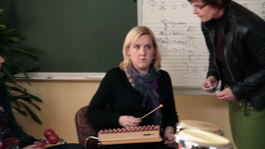 Right to left pan shot of the group of people that are learning a new song