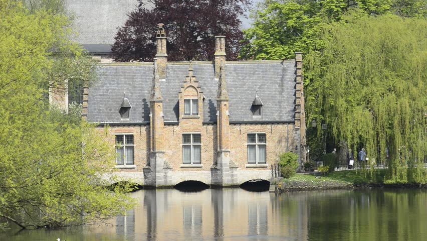 Minnewater lake (Lake of Love) in Bruges, Belgium: zoom out of the Sluice House (Sashuis) on the lake