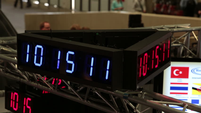 Electronic clock shows time spin at business convention fast motion. Business men and woman walk the floors and interact trade show in Las Vegas Convention Center. Annual meeting and trade show. 