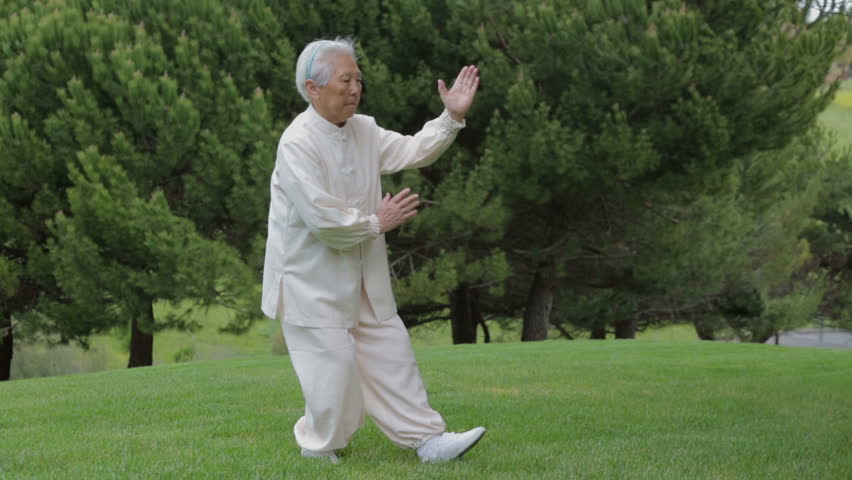 78 Old Asian Chinese Female Practicing Tai Chi at outdoor park under sunny day