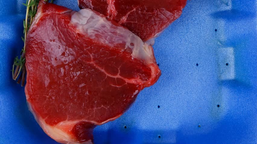 uncooked raw beef fillet with thyme twig on blue tray 1920x1080 intro motion slow hidef hd