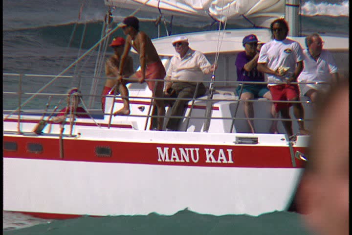 WAIKIKI BEACH, HONOLULU, HAWAII - JANUARY 30, 1997: scenic b-roll at Waikiki Beach, Hawaii: MS yacht close to shore. Men relaxing on deck of yacht.