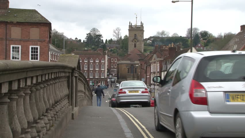 BEWDLEY, UK - APRIL 2012: A busy line of cars traveling over an old decorated bridge.