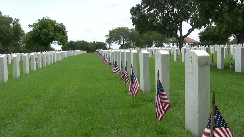 Video zoom in of the Fort Sam Houston Veterans Cemetery. Headstones and flags. Grass headstones flags. Memorial Day holiday.San Antonio, Texas. Don Despain of Rekindle Photo