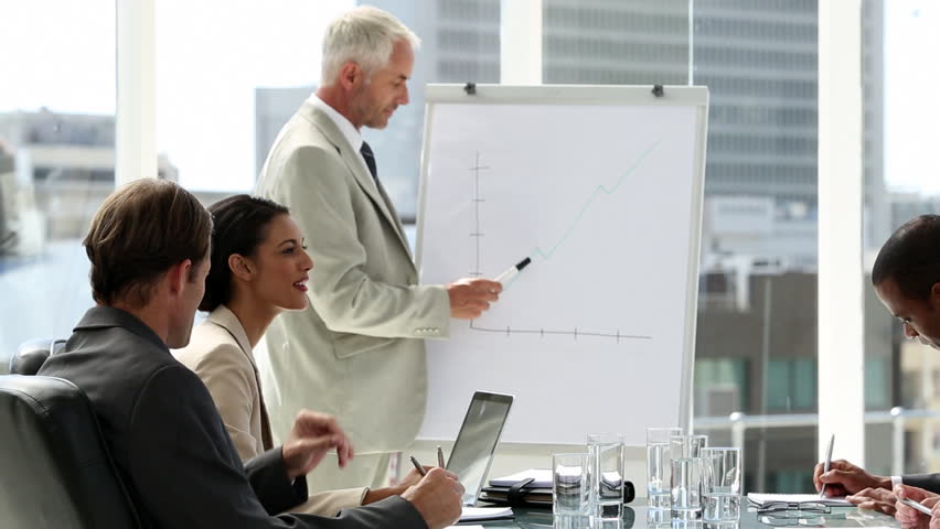Businessman presenting to the team taking notes in the boardroom
