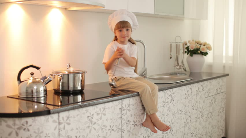 Girl Sitting On The Kitchen Table With A Ladle And Smiling Stock ... Girl Sitting On The Kitchen Table With A Ladle And Smiling Stock ...