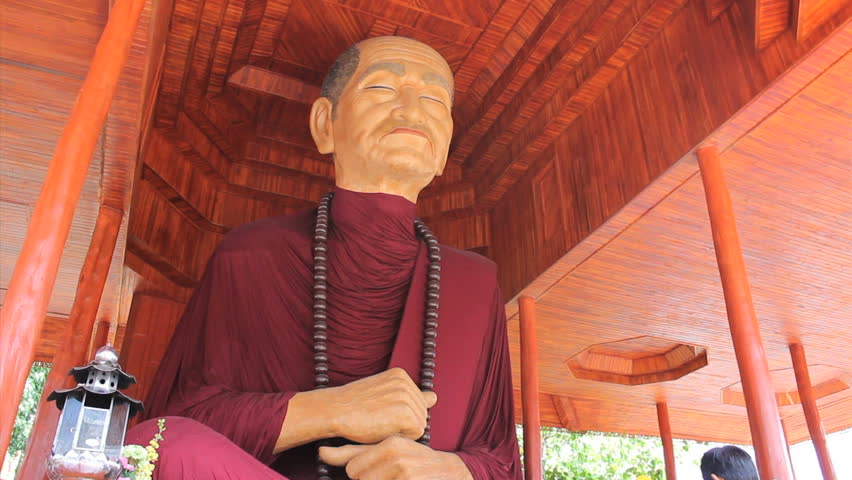 BANGKOK, THAILAND, 2013: A man can be seen paying respects to a huge oversized Buddhist monk statue in Bangkok, Thailand.