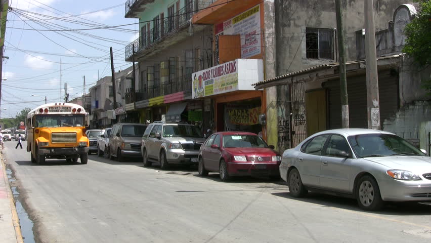 Video of border city Matamoros Mexico city street with bus. Public transportation.  Across from Brownsville TX. Mexicans and tourist walking, very old buildings. Poor. Don Despain of Rekindle Photo