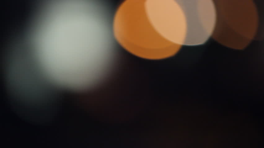 Bokeh,  Colorful circle spot lights Moving is Out of focus. filming  from car light in night city, realistic cinema, film, movie for abstract background and texture