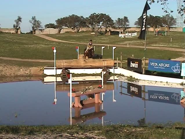 Horseman galloping and jumping the fence