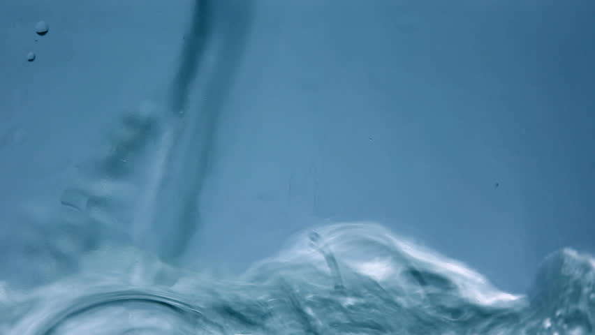 Water is pouring into a glass container