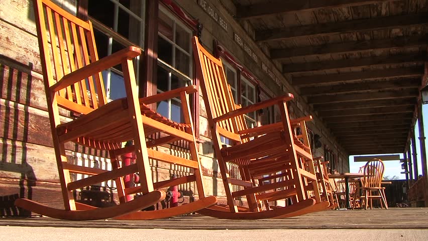 Rocking chairs in the wind on an old porch. Ghost town.