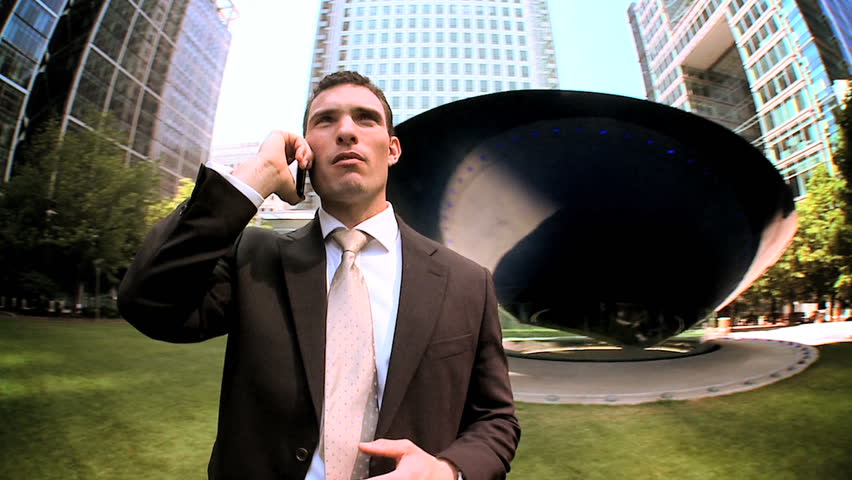 Steadicam with young city business man using a mobile(cell) phone