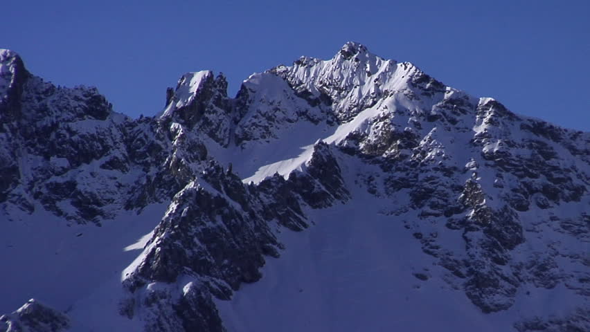 Panorama shot over alpine peaks in winter; 2 shots, static and a pan