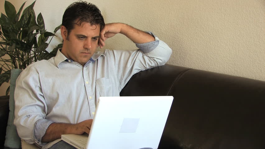 Man working on laptop starts with serious look then changes to happy expression.