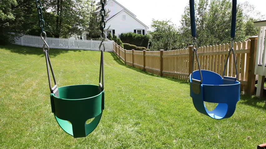 Empty swings in a backyard