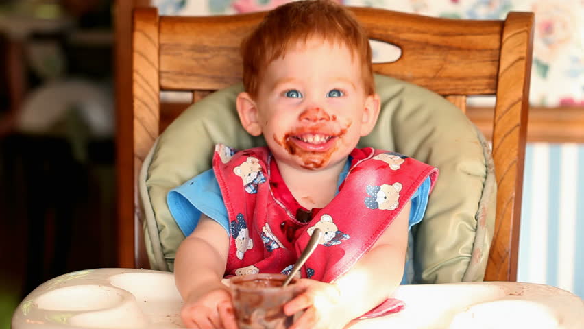 Baby getting messy eating chocolate pudding in HD