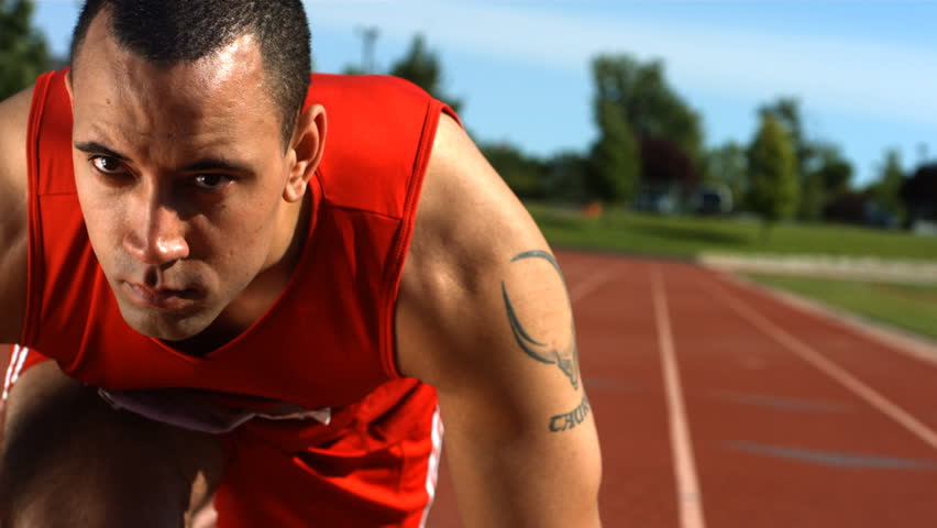 Closeup of track runner at starting line, slow motion