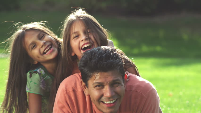 An adorable family pose for the camera. Medium shot.