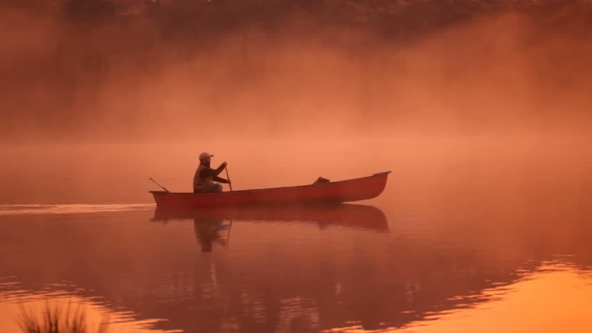 Paddling canoe at sunrise