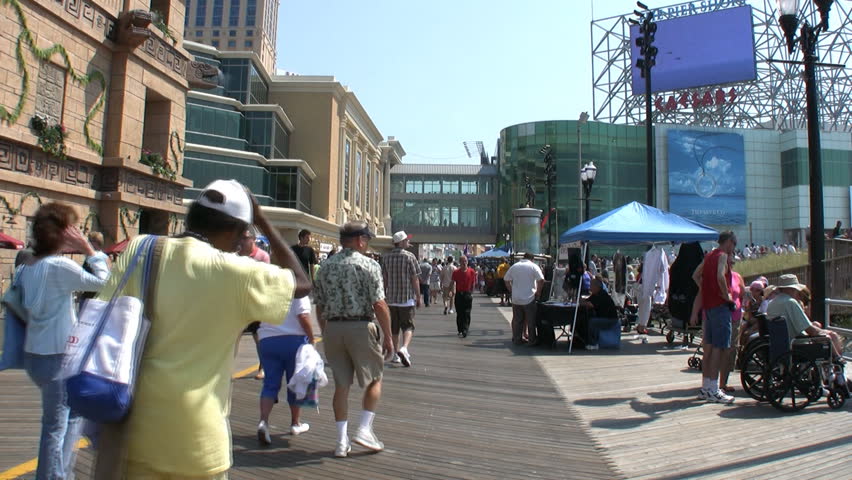 People walking on the boardwalk at Atlantic City with the screen of the Airshow