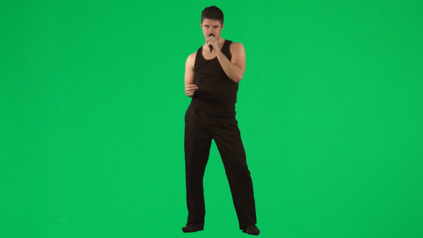 Man singing with a microphone against green screen