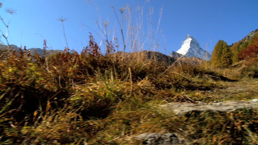 Fall in an alpine meadow, Zermatt, with female hiker & the Matterhorn, motion jib