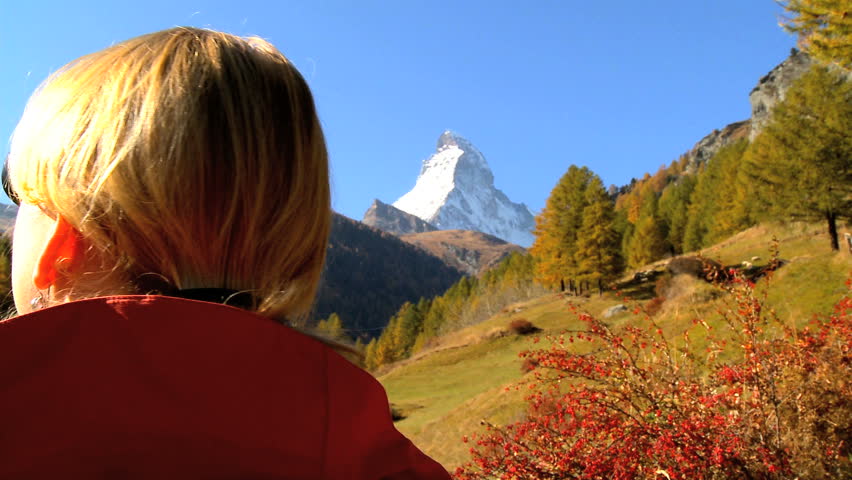 Fall in an alpine meadow, Zermatt, with female hiker & the Matterhorn, Switzerland