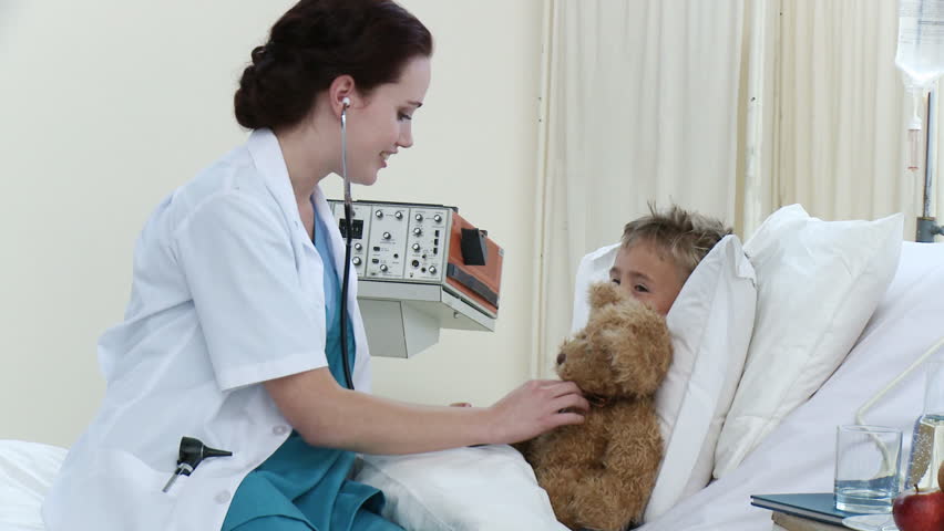 Footagein high definition if beautiful doctor talking and playing with a little boy recovering in hospital. Concept of healthcare