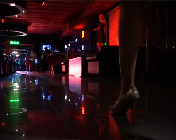 Close-up of lady steps over floor in night club  