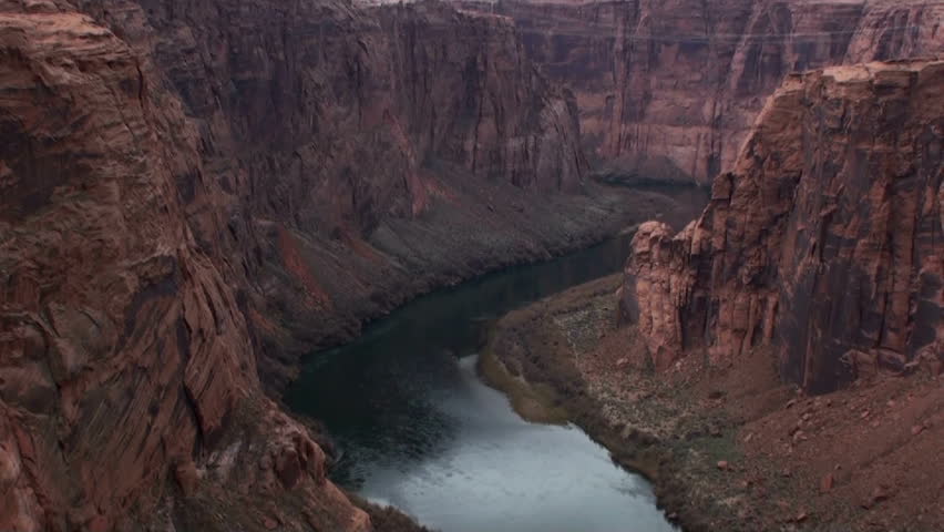 Pan across Colorado River cuts through canyon rock leading to Glen Canyon Dam. 1920x1080