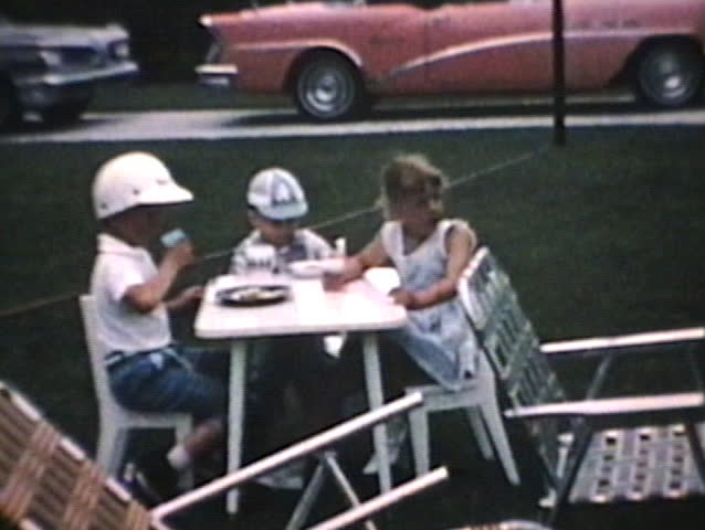 Friends and family get together to share a meal and some laughs at a picnic in 1964.