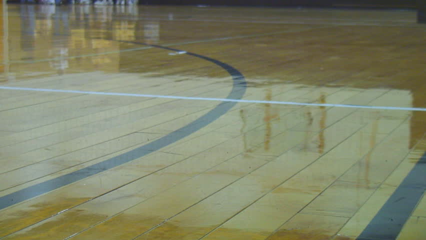 Floor angle of volleyball rolling away on hardwood floor