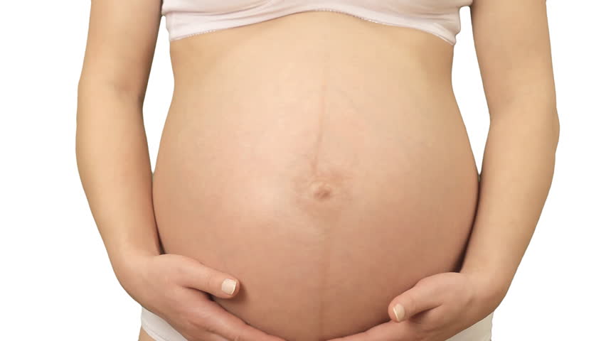 Pregnant Caucasian woman holding and stroking her abdomen 