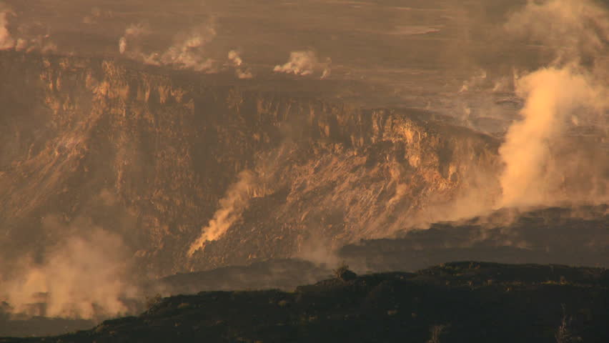 Hot steam energy escaping from a rocky volcanic crater in barren landscape