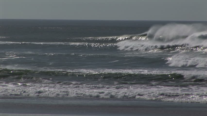 Pacific ocean silky misty waves with white frothy foam breaking on beach US