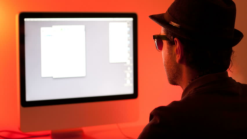 Time lapse of a young man in front of a computer on a color-full background