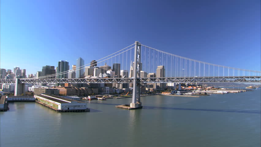 Low aerial view of Oakland Bay Bridge & skyscrapers of San Francisco, USA