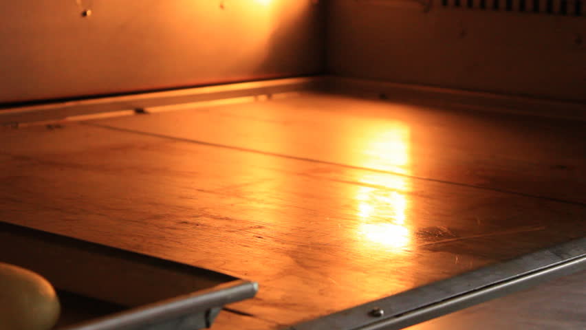 Putting bread rolls into an oven. 