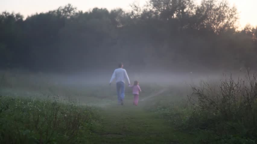 girl with daddy keeping for hands go on wood footpath in morning fog 