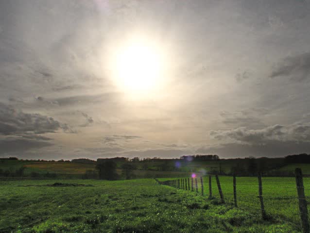 Storm rolling over hills, occulting the sun. HD time lapse clip.