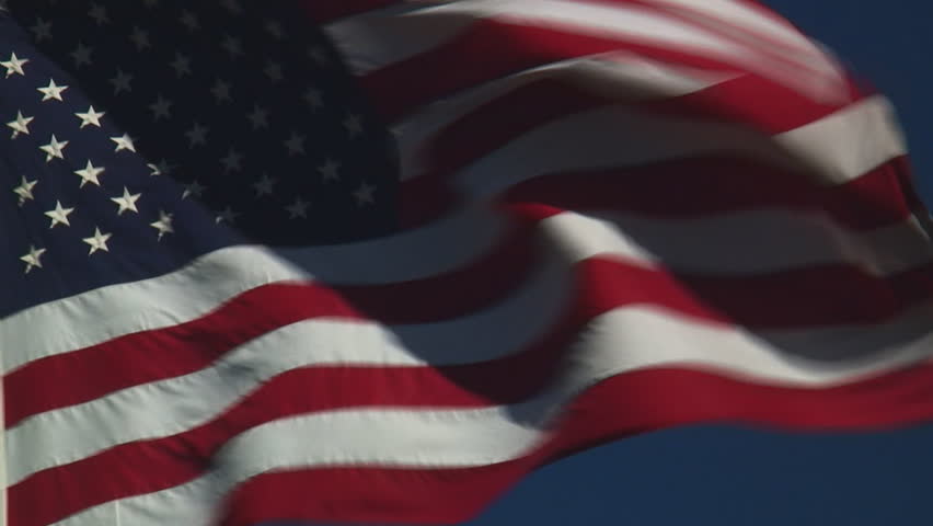 real United States of America flag flying flying against clear blue sky - HD, no audio, tight shot