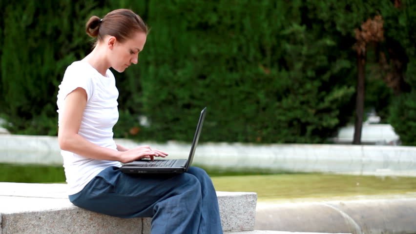 Attractive woman with laptop, outdoors - 720p