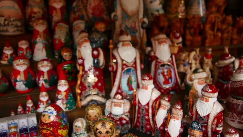 Many souvenir beautiful Russian wooden dolls, which are called Matryoshka and figures of Father Frost are on counter in a shop