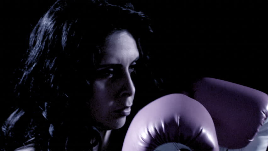 A Latino woman boxes.