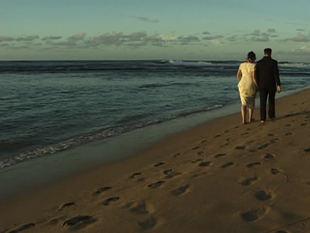 Wedding couple walking on empty Hawaii beach