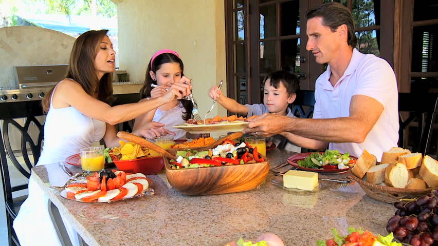 Attractive caucasian family sitting at home sharing a healthy meal together 60FPS