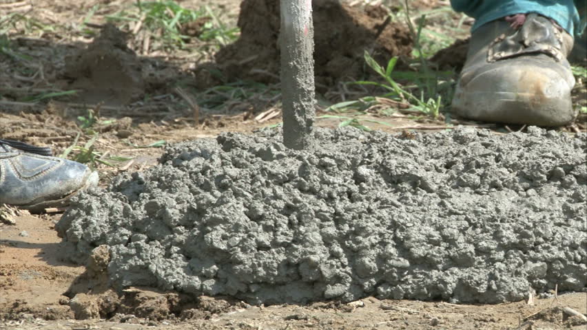 Geodesist with workers are inserting and adjusting pillar in cement for solar power plant construction. 