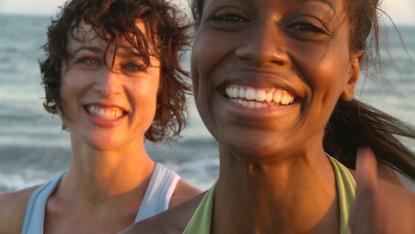 Portrait of two young women at beach during sunset