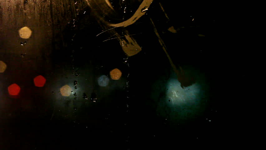 Tram's steamy rear window view. Cold weather cityscape. Night time. Focus on window. Outside blurred lights. Christmas night.